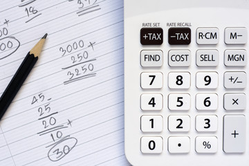 Calculator and pencil on note paper with calculation concept select focus