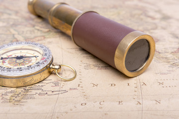 Fototapeta na wymiar Old compass and old telescope on vintage map world explorer concept