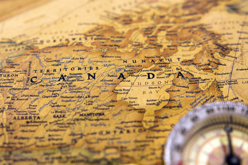 Old compass on vintage map selective focus on Canada