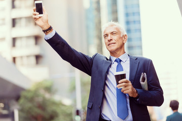 Businessman catching taxi in city