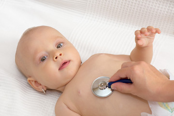 Doctor exams baby with stethoscope, isolated