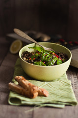 Tazza con insalata di lenticchie e bietole fresche; accanto crostini di pane appoggiati su stoffa verde 