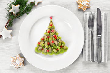 Christmas fir tree made from kiwi, on plate, close up