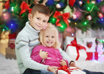 Fototapeta na wymiar Funny kids with gift boxes and Christmas tree on background