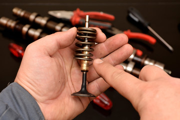 car mechanic shows how valve parts are assembled, inside cylinder head