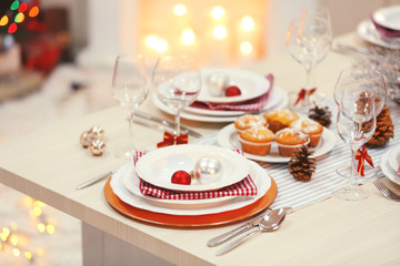 Christmas table setting with holiday decorations on fireplace background