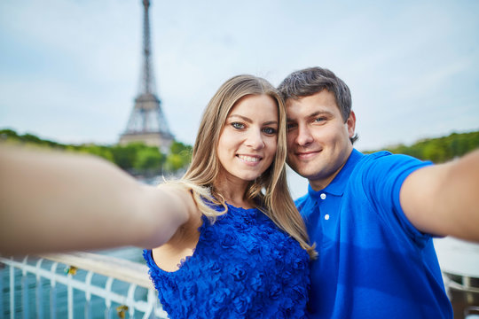 Beautiful young dating couple in Paris making selfie