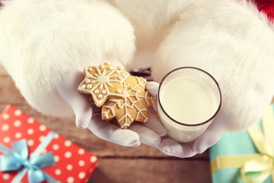 Christmas concept. Santa with glass of milk and cookies in hands, close up