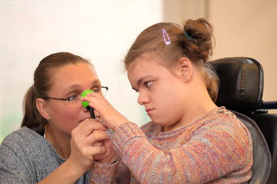 Disability A Disabled Child Enjoying Music Therapy / Disability A Disabled Child In A Wheelchair Enjoying Music Therapy With A Carer