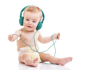 Happy baby with headphones listening to music on white backgroun