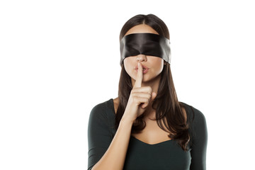 young blindfolded woman making a silent gesture