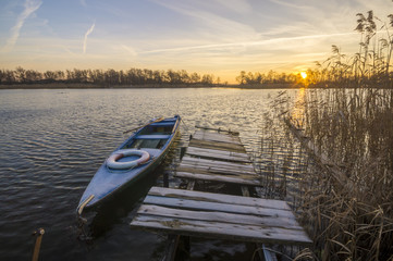 łódka zacumowana zimą do drewnianego pomostu 