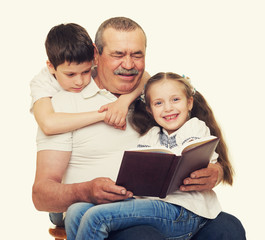 Grandfather and grandchildren read book