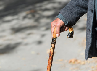 Senior man holding a wooden stick