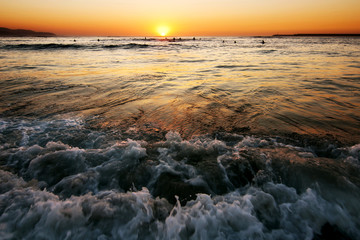 surfer men silhouettes  in the beach shore at sunset