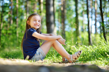 Adorable little girl hiking in the forest