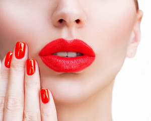Fototapeta premium Red Sexy Lips and Nails closeup. Open Mouth. Manicure and Makeup. Make up concept. Kiss.Beautiful young model face close up with red lips and red manicure.