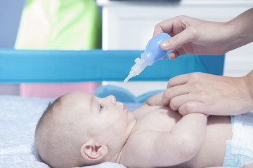 Mother using baby nasal aspirator