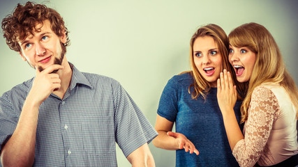 Two women talking gossiping about man.