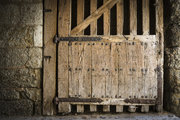 ancient wooden gate with rusty metal hinges