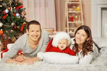 Happy family laying on the floor in the decorated Christmas room