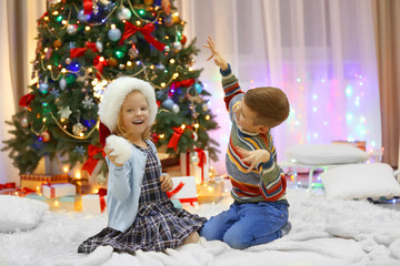Happy children playing with gifts in the decorated Christmas room