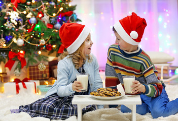 Happy children have a meal in the decorated Christmas room