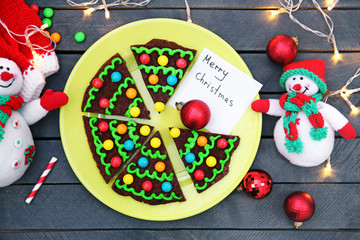 Fototapeta na wymiar Delicious colorful Christmas cookies on plate with festive decoration