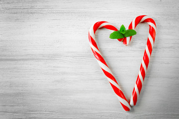 Lollipop candies like heart with mint on light background