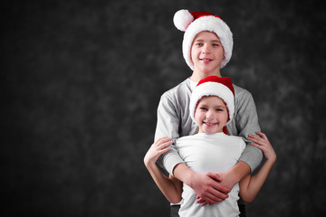 Obraz premium Brothers in Santa hats on grey background