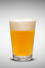 Glass of fresh beer with cap of foam isolated on white backgroun