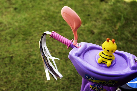a toddler tricyle with squakey toy on blurred background. image contained small depth of field