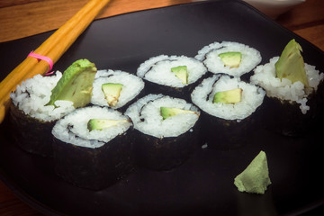 Japanese vegetarian roll with avocado on the black plate