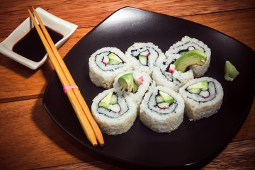 Japanese roll with crab and avocado on the black plate