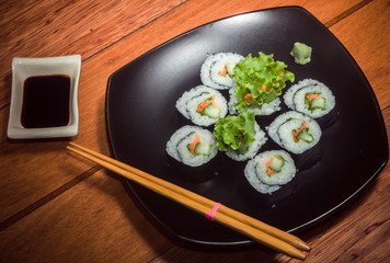 Japanese vegetarian roll with cucumber, carrot and iettuce on the black plate