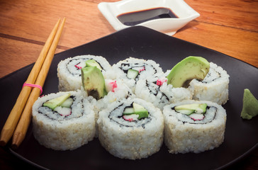 Japanese roll with crab and avocado on the black plate
