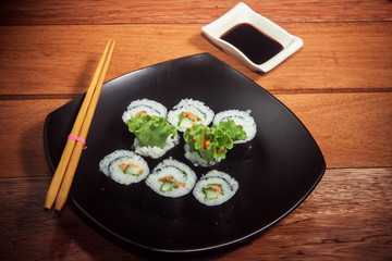 Japanese vegetarian roll with cucumber, carrot and iettuce on the black plate