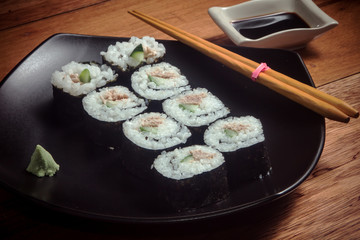 Japanese roll with tuna and cucumber on the black plate