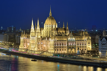 Fototapeta premium Eveninig view of the Hungarian Parliament Building in bright yellow illumination. View from Castle Hill in Budapest, Hungary.