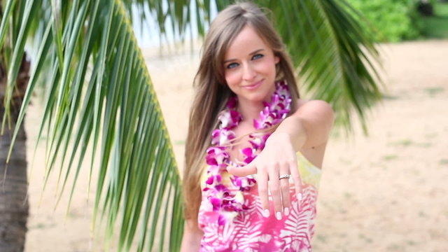 Girl wearing flower Lei and Showing engagement ring. Wedding concept on Hawaii. 