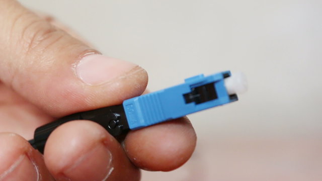 Hand of administrator holding bunch of optic fiber cables with
