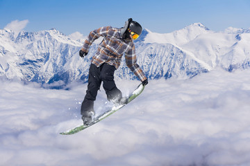 Flying snowboarder on mountains. Extreme sport.