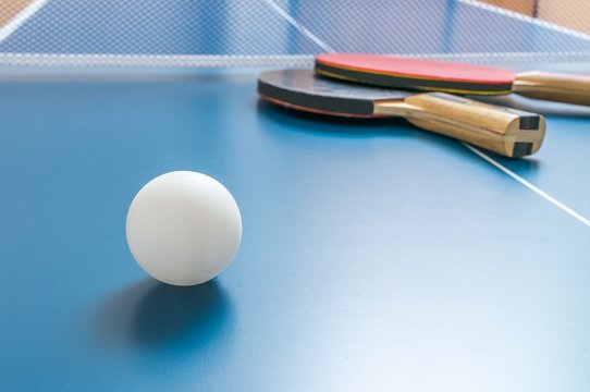 White Ball For Table Tennis Or Ping Pong On Wooden Table.