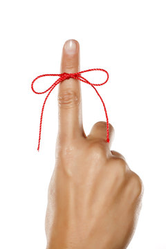 index finger tied with a red rope