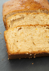 sliced orange cake on a slate trivet