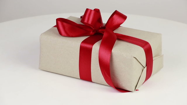 Gift box covered with wrapping paper and red bow