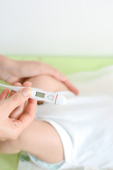 Checking baby temperature which indicates high fever on thermometer