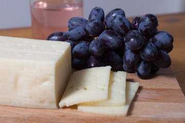 cheese and grapes on the wooden table