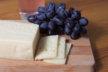 cheese and grapes on the wooden table