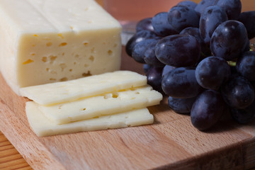 cheese and grapes on the wooden table
